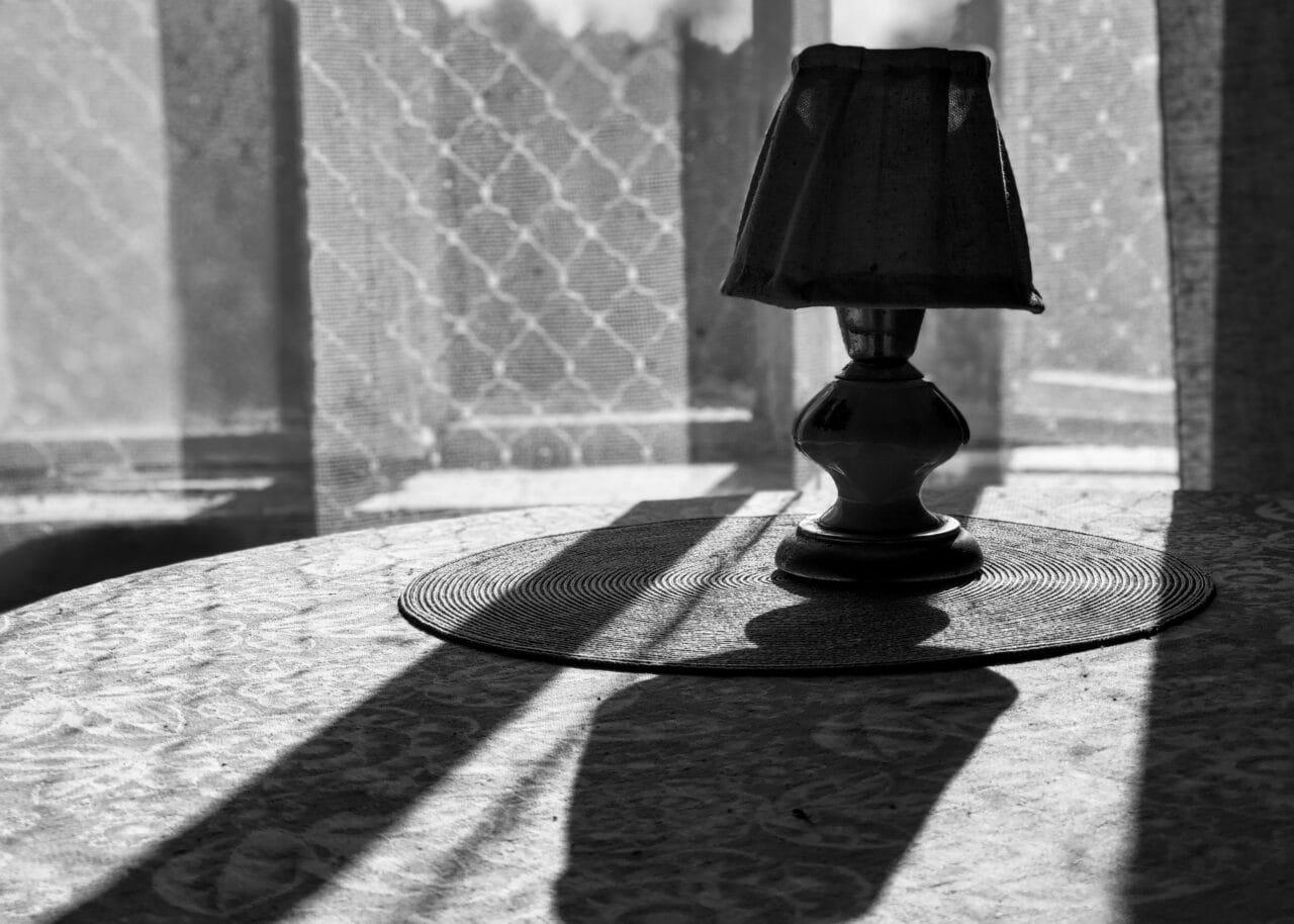 A monochrome image of a table lamp, showcasing its elegant design and contrasting shades